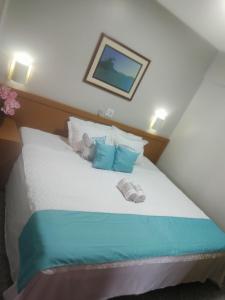 a bed with blue and white sheets and pillows at FLAT FUNCIONAL e ECONÔMICO,CENTRO-GO in Goiânia