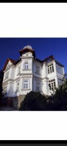 ein großes weißes Gebäude mit einem Turm oben in der Unterkunft Villa Reder in Bad Sauerbrunn