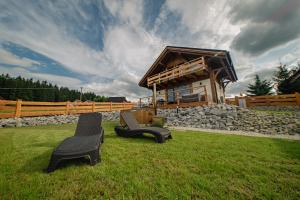 two chairs sitting in the grass in front of a building at Beskidzka Oaza in Istebna