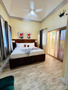 - une chambre avec un lit et un ventilateur de plafond dans l'établissement Villa Panorama, à Montego Bay