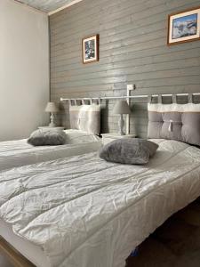 uma cama grande com duas almofadas num quarto em Le Chalet de Larcat em Larcat