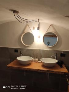 een badkamer met 2 wastafels en 2 spiegels bij La casa del Gigante Frassino in Acceglio