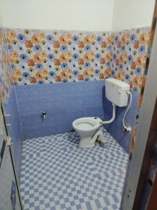 uma casa de banho com um WC numa parede azul em Gourinandan lodge em Puri