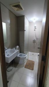 uma casa de banho com um lavatório, um WC e um chuveiro em Hilanders Condotel Across Terminal 3 em Manila