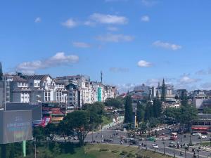 una città con una strada trafficata con auto e palazzi di Gold Dream Hotel a Da Lat