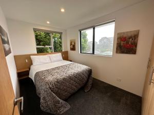 ein kleines Schlafzimmer mit einem Bett und einem Fenster in der Unterkunft Plymouth Central City 2 Bedroom Apartments in New Plymouth