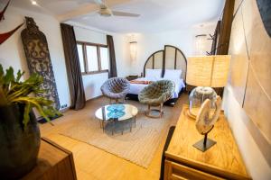 a bedroom with a bed and chairs and a table at Villa Loba in Seminyak