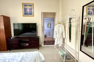 una camera da letto con TV, cassettiera e specchio di Narai - Home Stay in Thapthan (A) a Ban Nong Chum Saeng