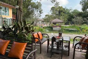 un patio con sedie, tavoli e laghetto di Narai - Home Stay in Thapthan (A) a Ban Nong Chum Saeng