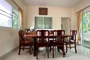 una sala da pranzo con tavolo e sedie in legno di Narai - Home Stay in Thapthan (A) a Ban Nong Chum Saeng