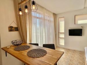 a dining room with a wooden table and a window at Lighthouse - Private apartment - BSR - 4 in Sveti Vlas