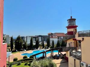 a building with a lighthouse and a swimming pool and a building at Lighthouse - Private apartment - BSR - 4 in Sveti Vlas