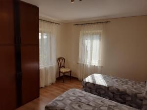 1 dormitorio con 2 camas, silla y ventanas en Il Casale, en Penna San Giovanni