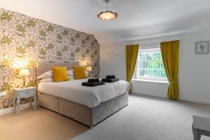 a bedroom with a large bed with yellow pillows at Holyland House - Greenacres Estates in Pembrokeshire