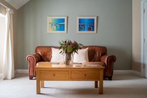 a living room with a couch and a table with a vase on it at Holyland House - Greenacres Estates in Pembrokeshire