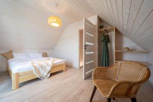 sypialnia z łóżkiem i krzesłem na poddaszu w obiekcie Natura Health Resort w mieście Darłowo
