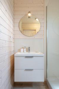 W łazience znajduje się biała umywalka i lustro. w obiekcie Natura Health Resort w mieście Darłowo