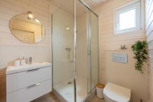 uma casa de banho com um chuveiro, um WC e um lavatório. em Natura Health Resort em Darłowo