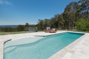a swimming pool with a bench next to at The MOST alluring getaway in Hunter Valley in Mount View