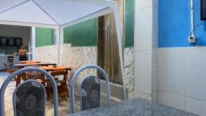 a patio with a table with a white umbrella at Hospedaria Além das Trilhas in Lençóis