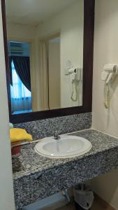 a bathroom counter with a sink and a mirror at Serene Holiday Chalet with pool in a quiet enclave in Kampong Alor Gajah