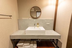 a bathroom with a white sink and a mirror at Irodori Hotel DAIDAI in Fukuoka
