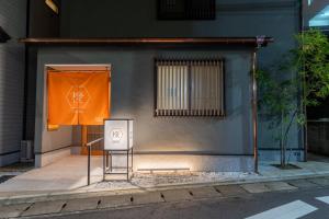 un edificio con una bandera naranja y un cartel en la calle en Irodori Hotel DAIDAI, en Fukuoka
