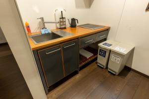 una pequeña cocina con fregadero y encimera en Irodori Hotel DAIDAI en Fukuoka