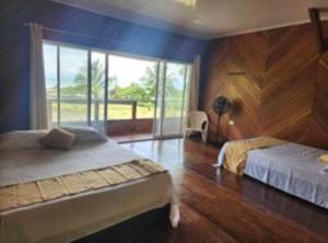 a bedroom with two beds and a large window at VILLA ENCANTO in El Valle