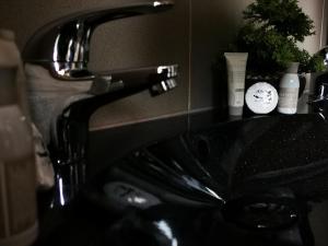 a black sink in a bathroom with a faucet at ALPINpelso in Sankt Michael im Lungau