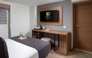 a hotel room with a bed and a desk with a television at Orka Royal Hotel & Spa in Istanbul