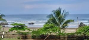 a view of a beach with palm trees and the ocean at VILLA ENCANTO in El Valle