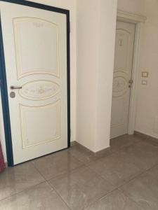 Zimmer mit zwei weißen Türen und Fliesenboden in der Unterkunft B&B Orchidea in Gioia Tauro