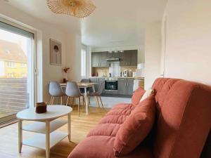 sala de estar con sofá rojo y cocina en L’heurt de la détente, en Le Portel