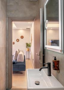 baño con lavabo y sofá en una habitación en Cactus Villas, en Mitikas