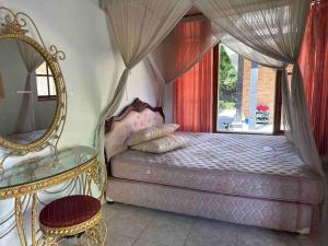 a bedroom with a canopy bed and a mirror at Jimbaran House in Jimbaran