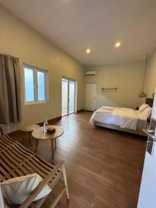 a bedroom with a bed and a table in a room at Vogelkopf Resort in Tapokreng