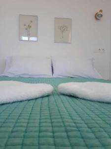 a bedroom with two twin beds with green sheets at Seaside Serenade 1, suite in Ermoupoli