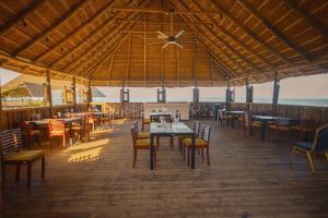 um restaurante com mesas e cadeiras num deque em Giraffe Beach Hotel em Dar es Salaam