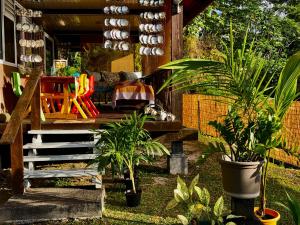 a patio with plants and a dog laying on a porch at Fare Mirimiri in Uturoa