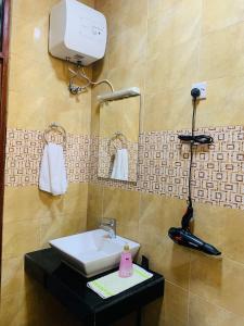 a bathroom with a sink and a hair dryer on a counter at Full equiped House with Free WiFi in Dar es Salaam