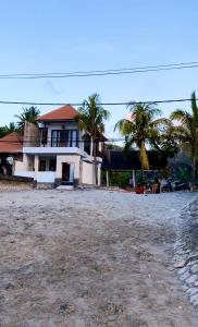 une maison sur la plage avec des palmiers dans l'établissement Amour Eternel Villa, à Nusa Penida