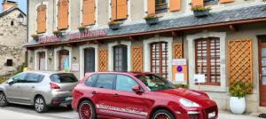 a red car parked in front of a building at La Ruche Cantalienne in Saint-Étienne-de-Chomeil