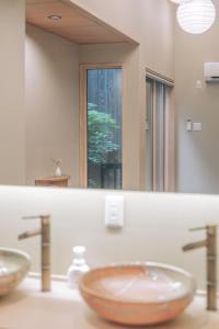 a bathroom with two sinks in front of a mirror at 櫛笥ノ家 Machiya Kushige in Kyoto