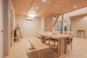 a dining room with a table and benches at 櫛笥ノ家 Machiya Kushige in Kyoto