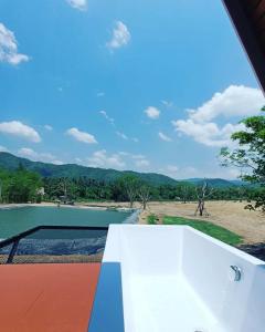 a view from the balcony of a house with a swimming pool at บ้านไร่ชายทุ่ง in Kanchanaburi