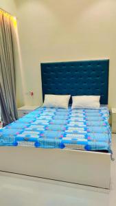 - un lit avec une tête de lit bleue dans l'établissement 2BHK VILLA IN the LAP OF NATURE, à Khandāla