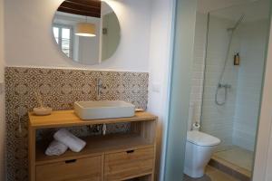 een badkamer met een wastafel, een spiegel en een toilet bij Es Mirador Hotel in Ciutadella