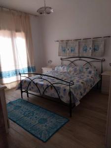 una camera con letto, finestra e tappeto di LA Pavoncella a La Maddalena