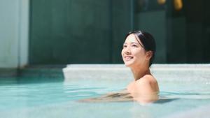 草津的住宿－Fourtreat Kusatsu，女人在游泳池游泳